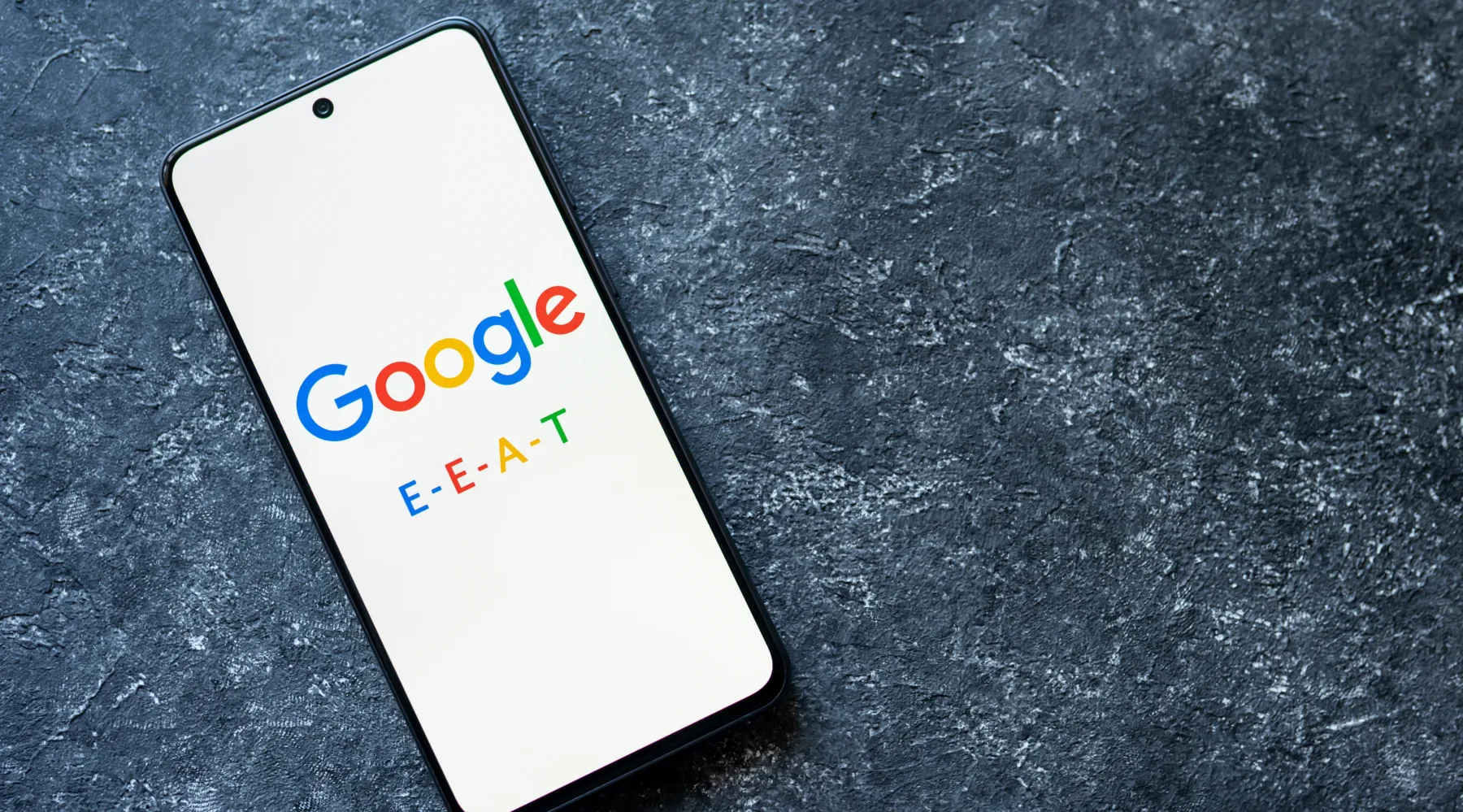 A mobile phone on a table with the Google logo and E.E.A.T.