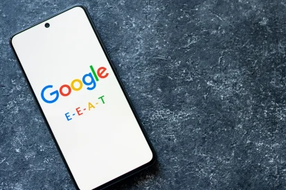 A mobile phone on a table with the Google logo and E.E.A.T.